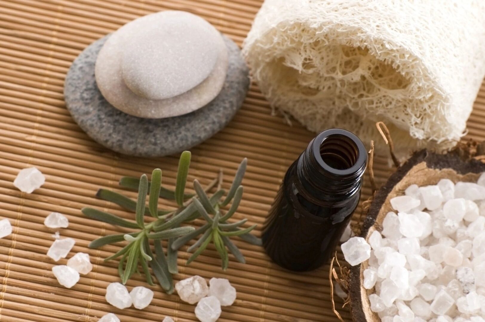 A bottle essential oil, stones, and towel